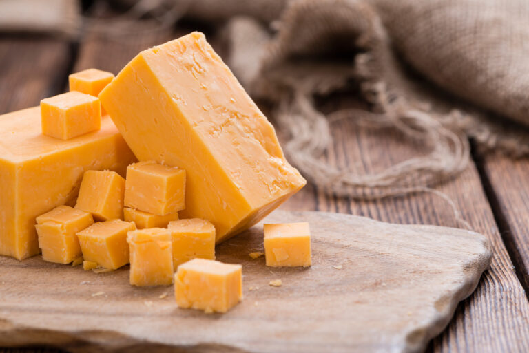 Pieces,Of,Cheddar,(close-up,Shot),On,An,Old,Wooden,Table