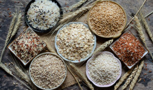 Top view of natural cereal food ingredients consisted of rice,wheat,and pearl barley in the bowl on grunge background in dark tone