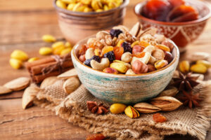 Dried raisins and (cashew) nuts in wooden bowl